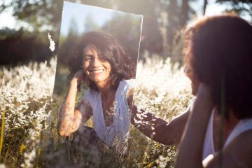 mujer con camisa floral-azul y blanca sonriendo mostrando manejo de emociones