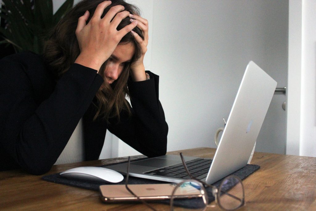 mujer sufriendo estrés laboral se cubre la cara con las manos